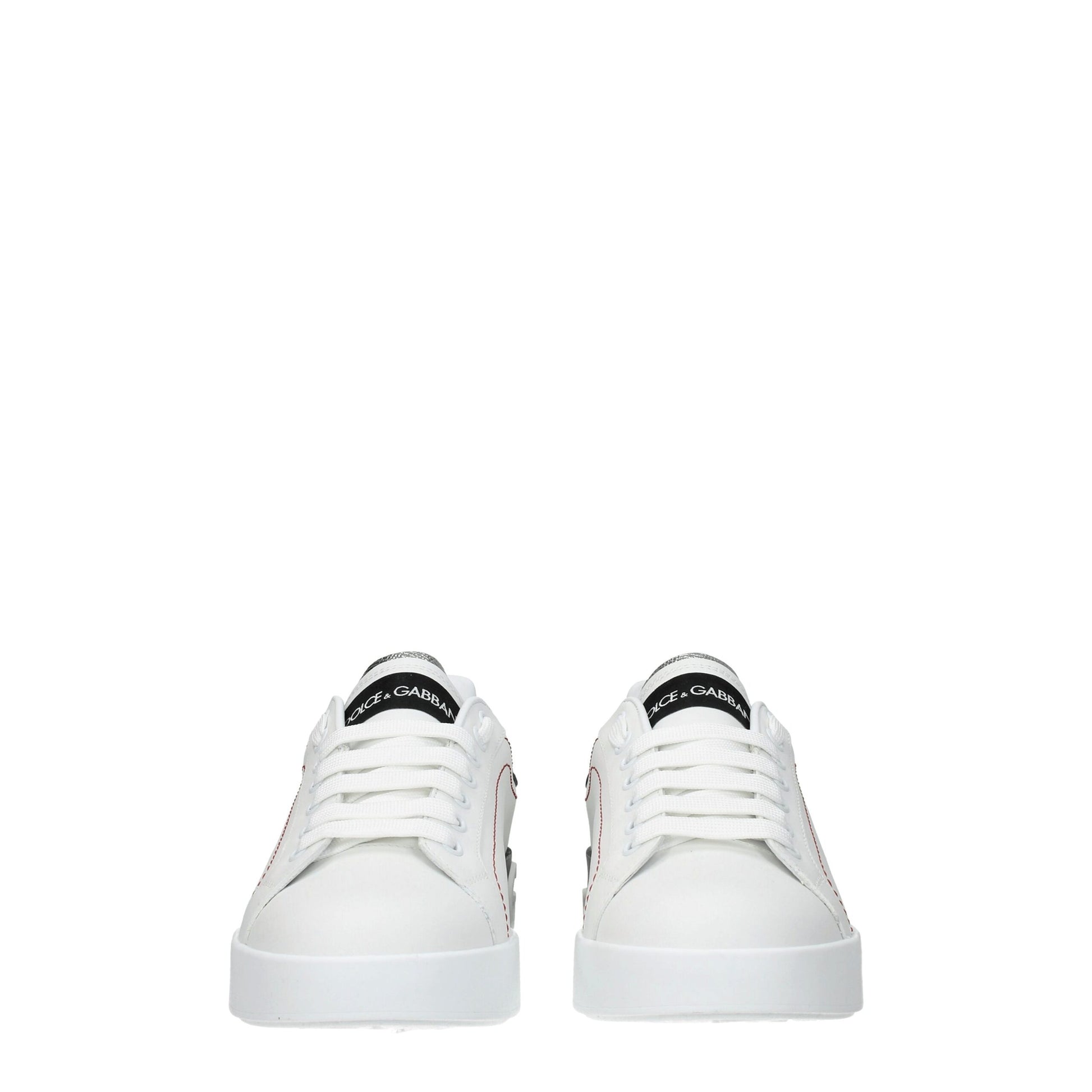 Female model wearing Dolce & Gabbana white leather low top sneakers with a clean white leather upper, signature branded detailing, and sleek low-profile sole, captured mid-step in a casual lifestyle pose showcasing the shoe's refined silhouette and luxury craftsmanship.