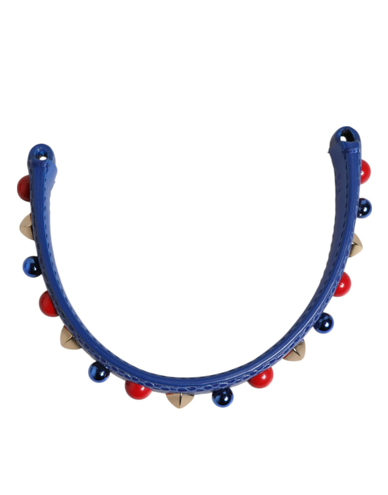 Blue leather bag handle embellished with red, blue, and gold studs