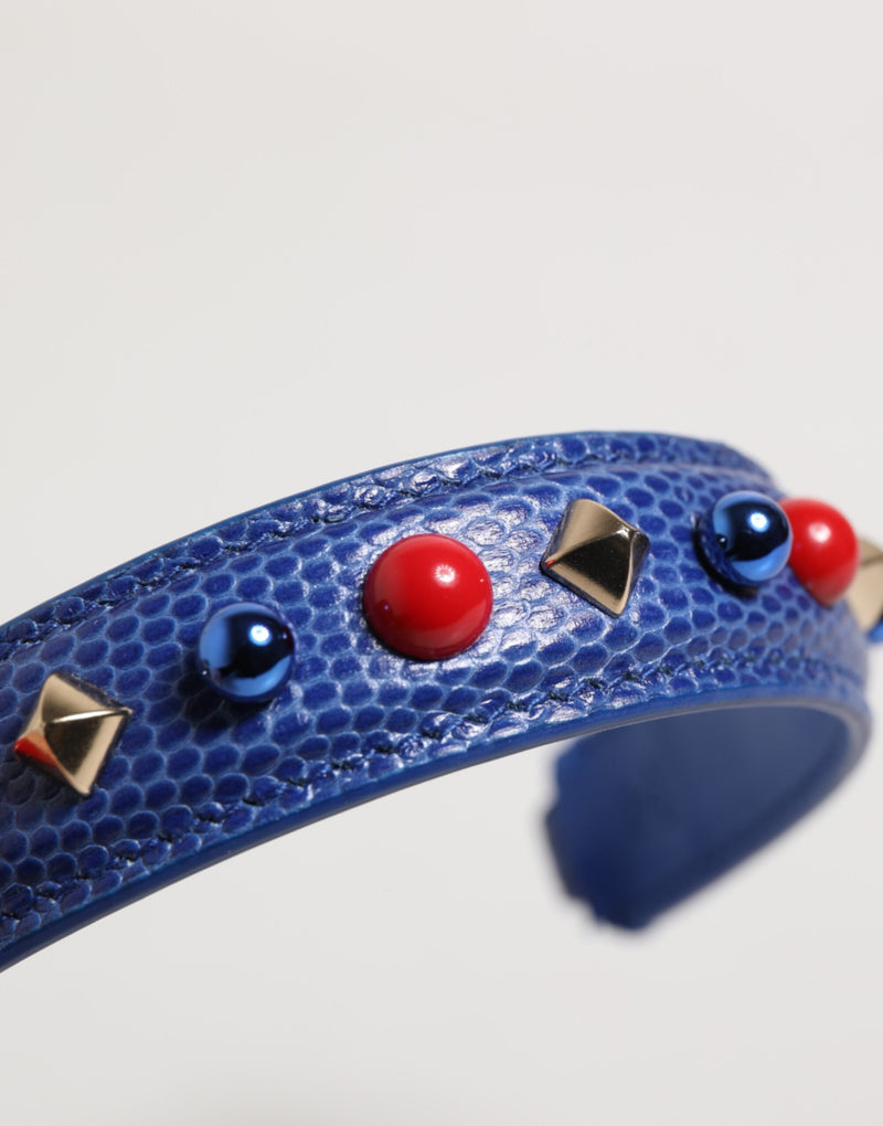 Blue textured leather bag strap embellished with red beads, blue spheres, and metallic pyramids