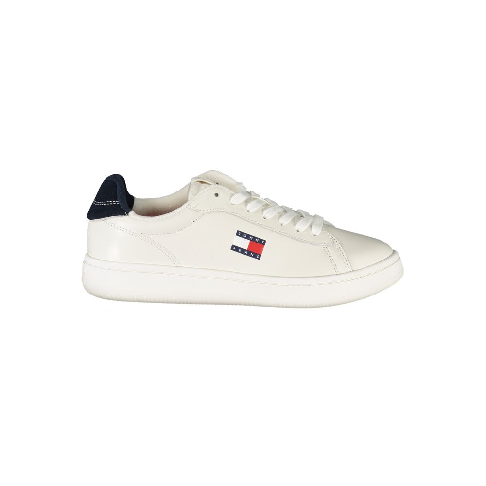 White polyurethane low-top sneaker with navy heel tab, white laces, and Tommy Jeans flag logo on the side.