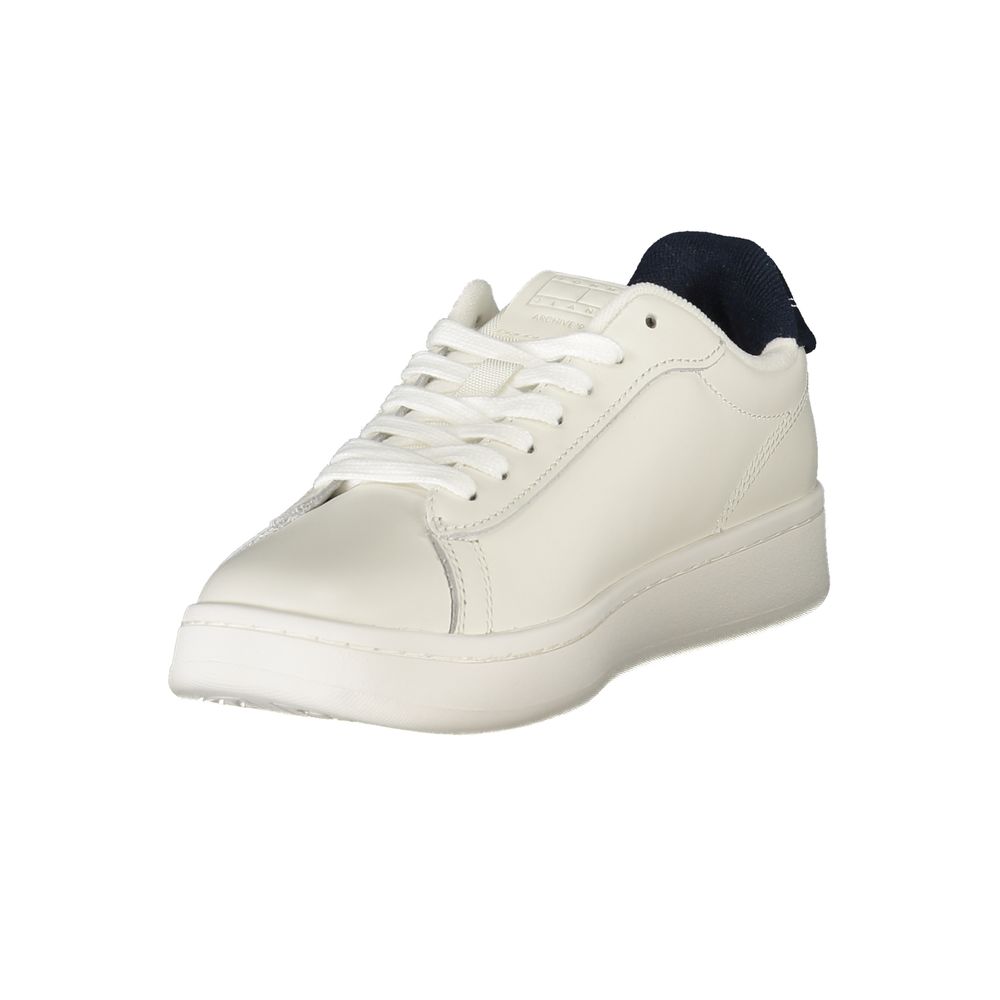 White polyurethane women's sneaker with white laces, a flat sole, and a dark blue fabric heel tab.