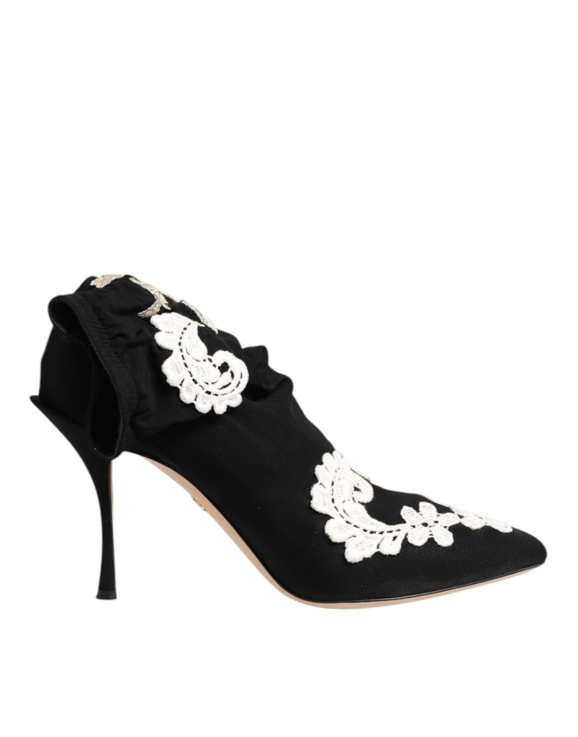 Black satin pointed-toe stiletto pump with white floral lace appliqué and ruffled ankle detail.