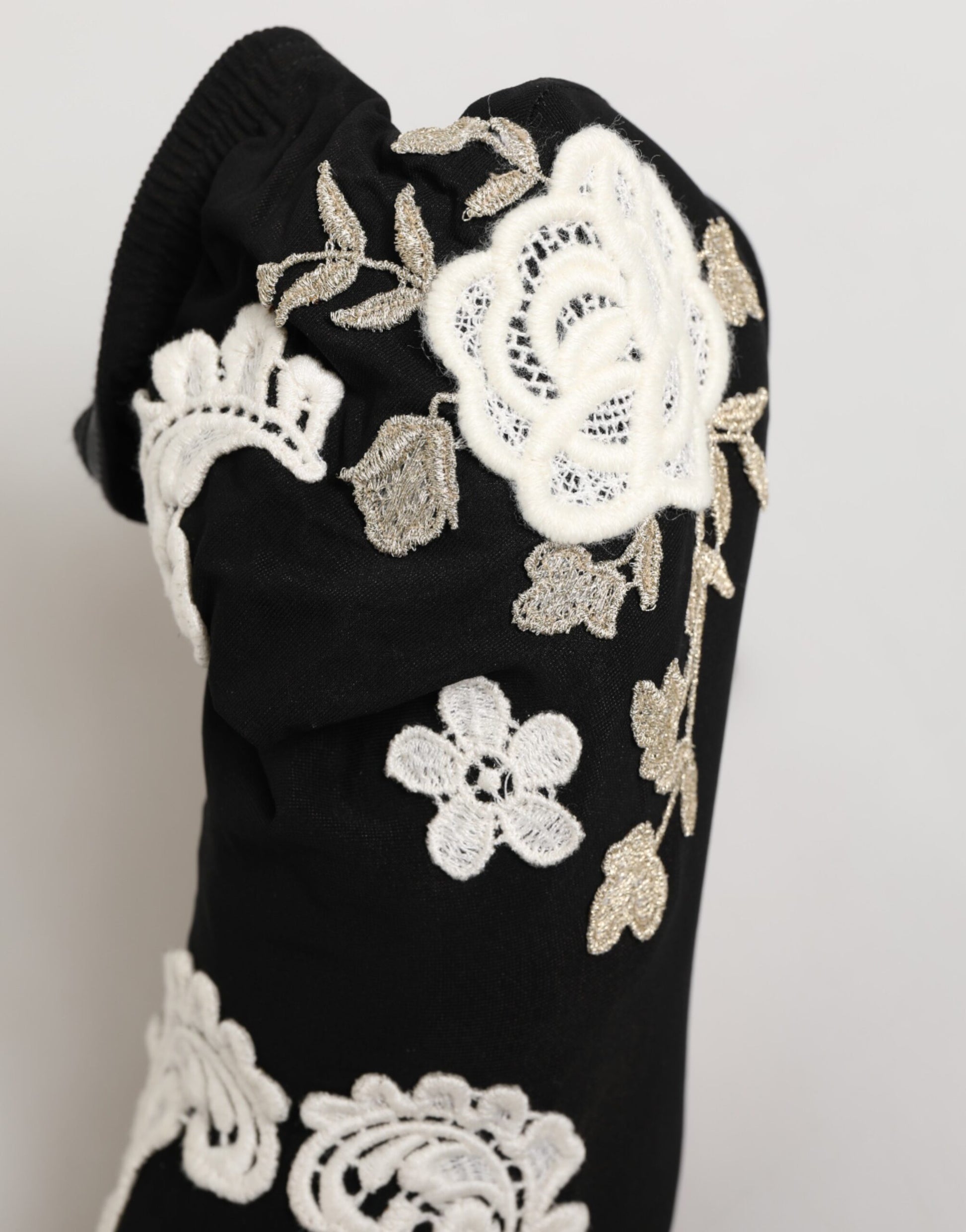Black fabric boot with white floral lace and metallic embroidery detailing.