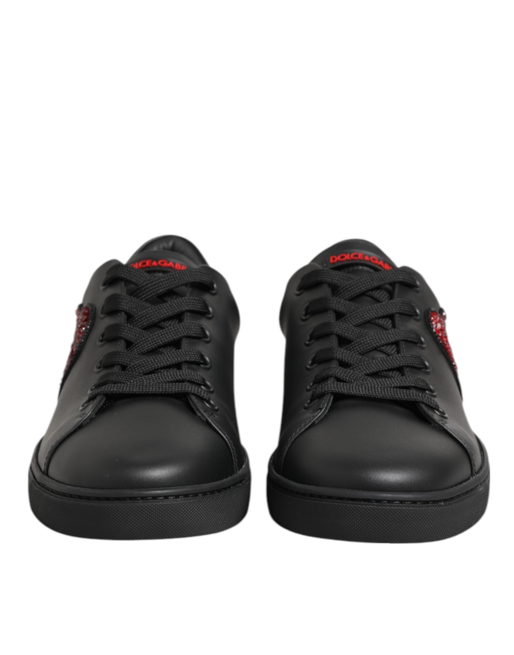 Black leather low-top sneakers featuring red crystal heart accents on the sides and red Dolce & Gabbana tongue branding.