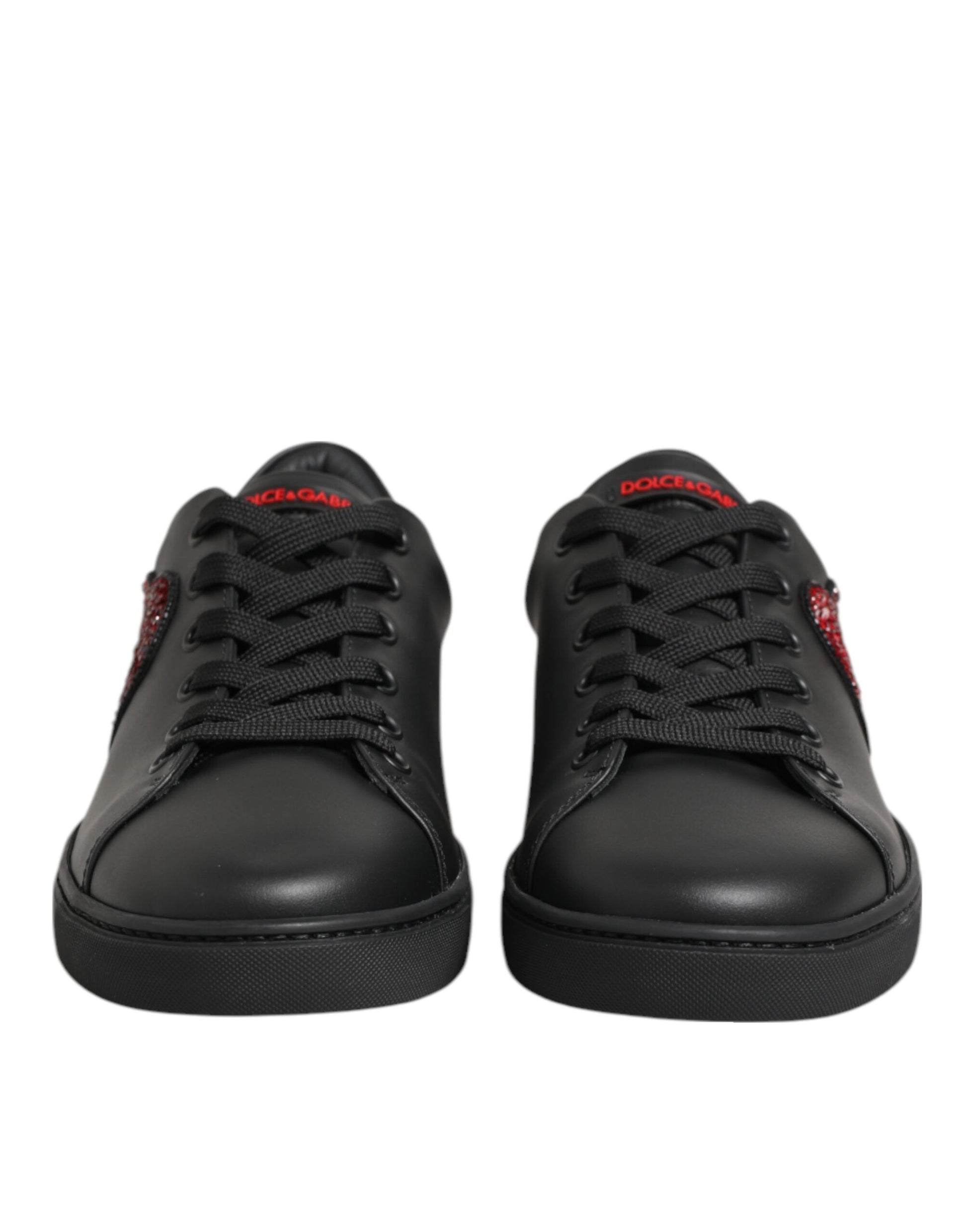 Black leather low-top sneakers featuring red crystal heart accents on the sides and red Dolce & Gabbana tongue branding.