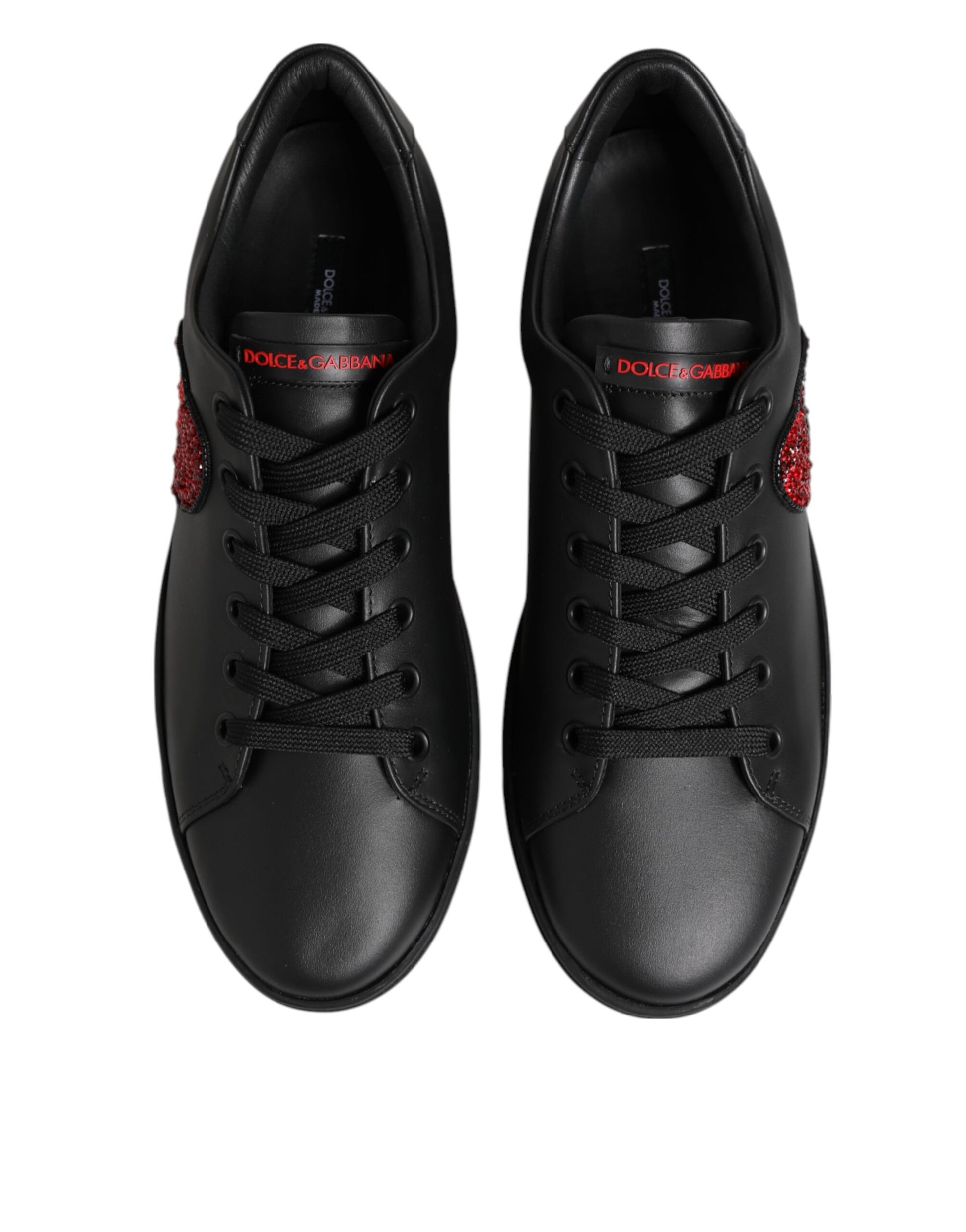 Black leather low-top sneakers with lace-up front, red crystal heart accents, and red Dolce & Gabbana tongue branding.
