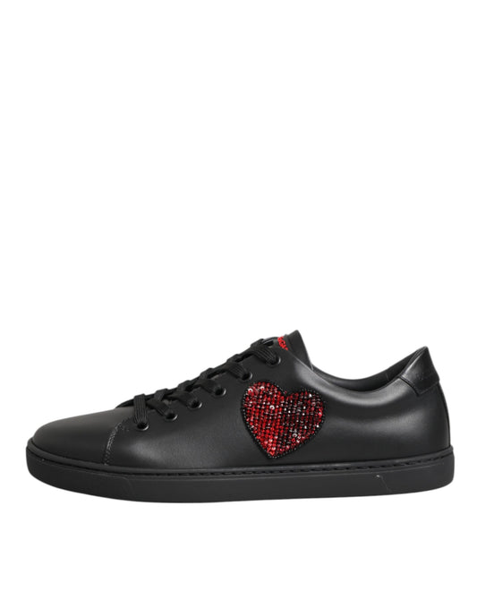 Black leather Dolce & Gabbana low-top sneakers featuring a red crystal-embellished heart appliqué on the side.