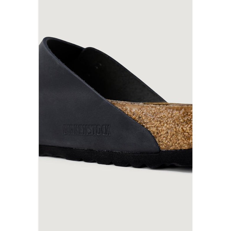 Close-up of a navy blue matte leather Birkenstock shoe with a signature cork footbed and black textured sole.