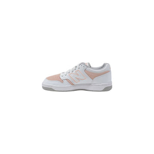 New Balance leather sneaker in white and soft pink with a perforated side panel, lace-up style, and grey sole.