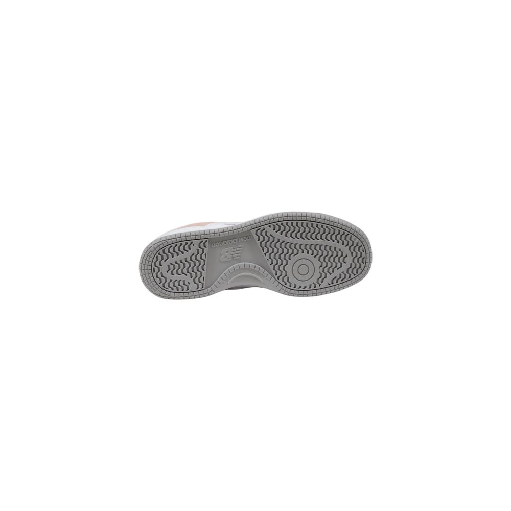 New Balance pink leather sneaker bottom view featuring a grey rubber outsole with a textured traction pattern.