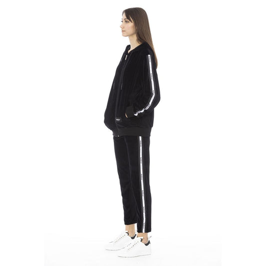 Black velvet zip-up hoodie and matching pants with white side stripes worn by a woman