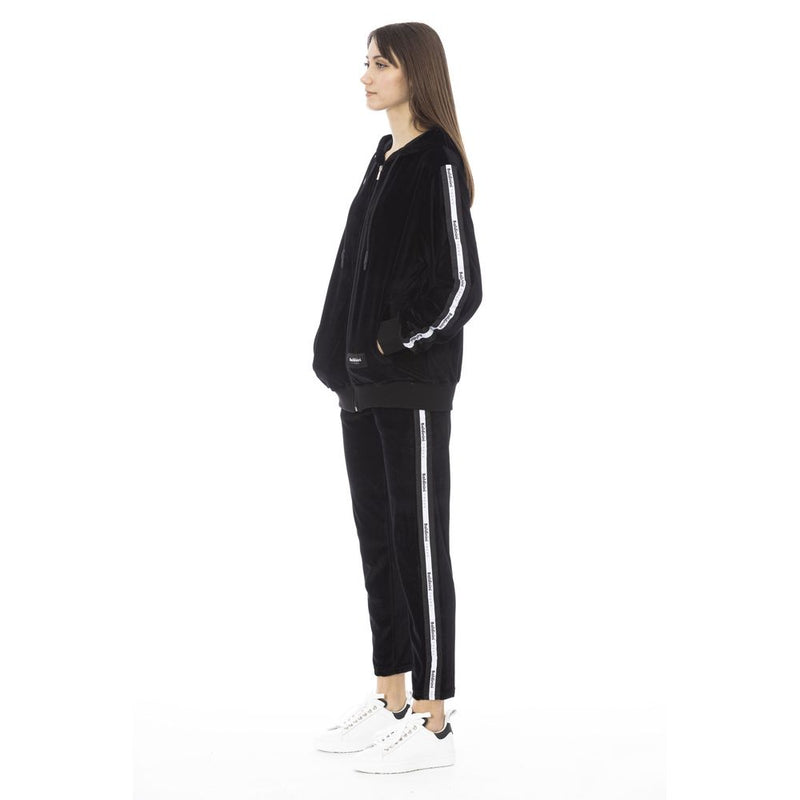 Black velvet zip-up hoodie and matching pants with white side stripes worn by a woman