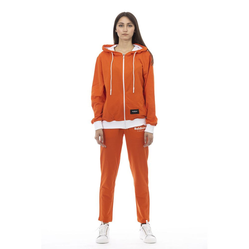 Woman wearing an orange cotton zip-up hoodie and matching sweatpants with white trim