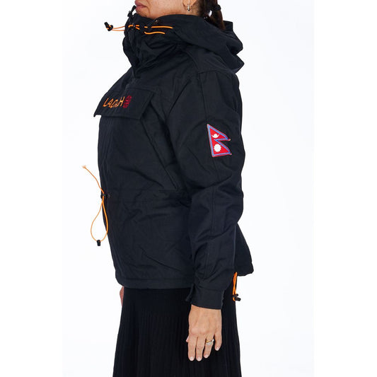 Black polyester hooded jacket with orange drawstrings and chest pocket worn by a woman