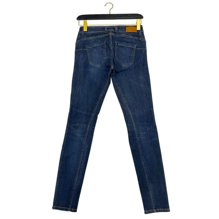 Blue cotton women's skinny jeans with button fly and stitched knee panels hanging on a black hanger