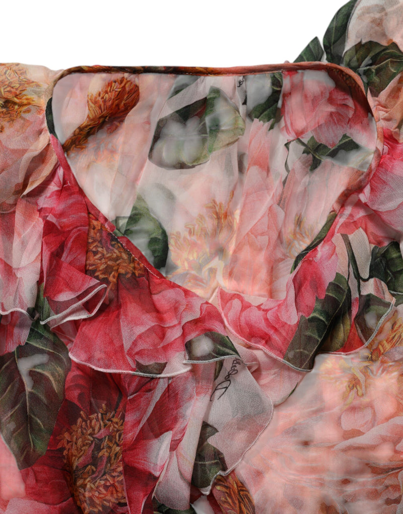 Pink silk V-neck blouse with a vibrant camellia floral print and ruffled trim