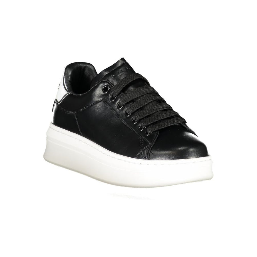 Gaelle Paris black polyurethane sneaker with lace-up front, thick white rubber sole, and white branded heel tab.
