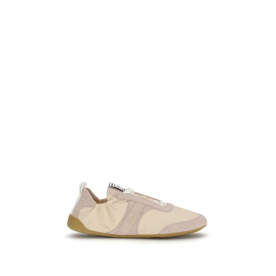 Beige nylon athletic sneaker by Chloé with suede overlays, a flat gum sole, and a relaxed, slip-on style silhouette.