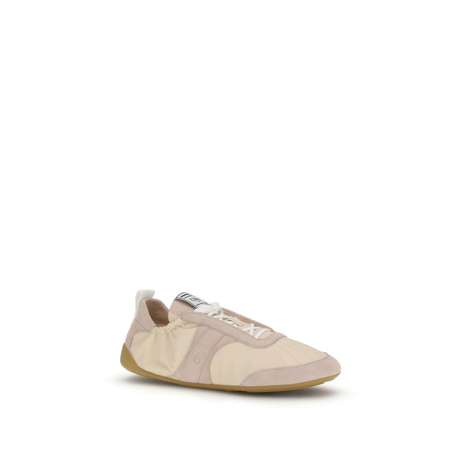 Beige nylon athletic sneaker by Chloé with suede overlays, a flat gum sole, and a relaxed, slip-on style silhouette.