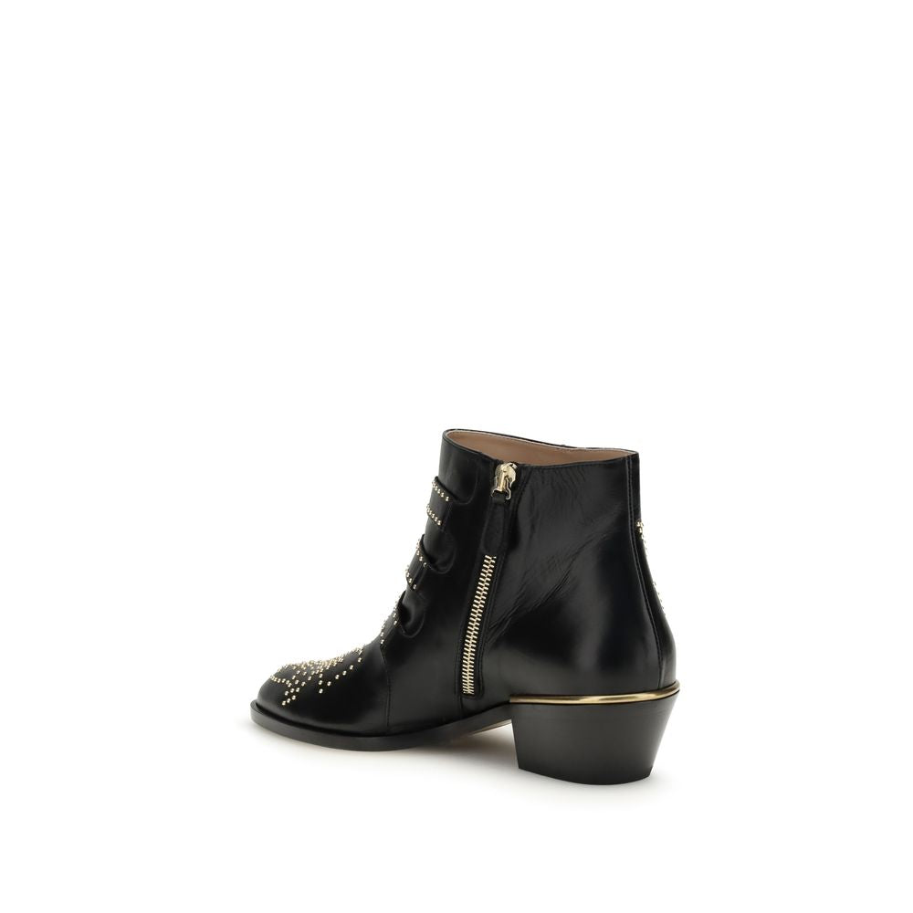 Chloé black calf leather ankle boots with gold-tone stud details, side zipper, and metallic heel trim.